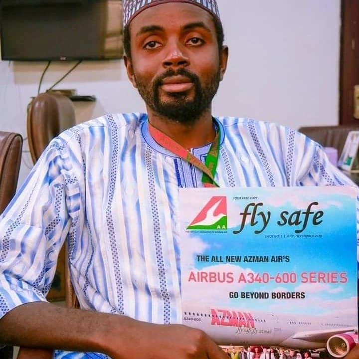 An Azman Air representative holding a Fly Safe Magazine issue