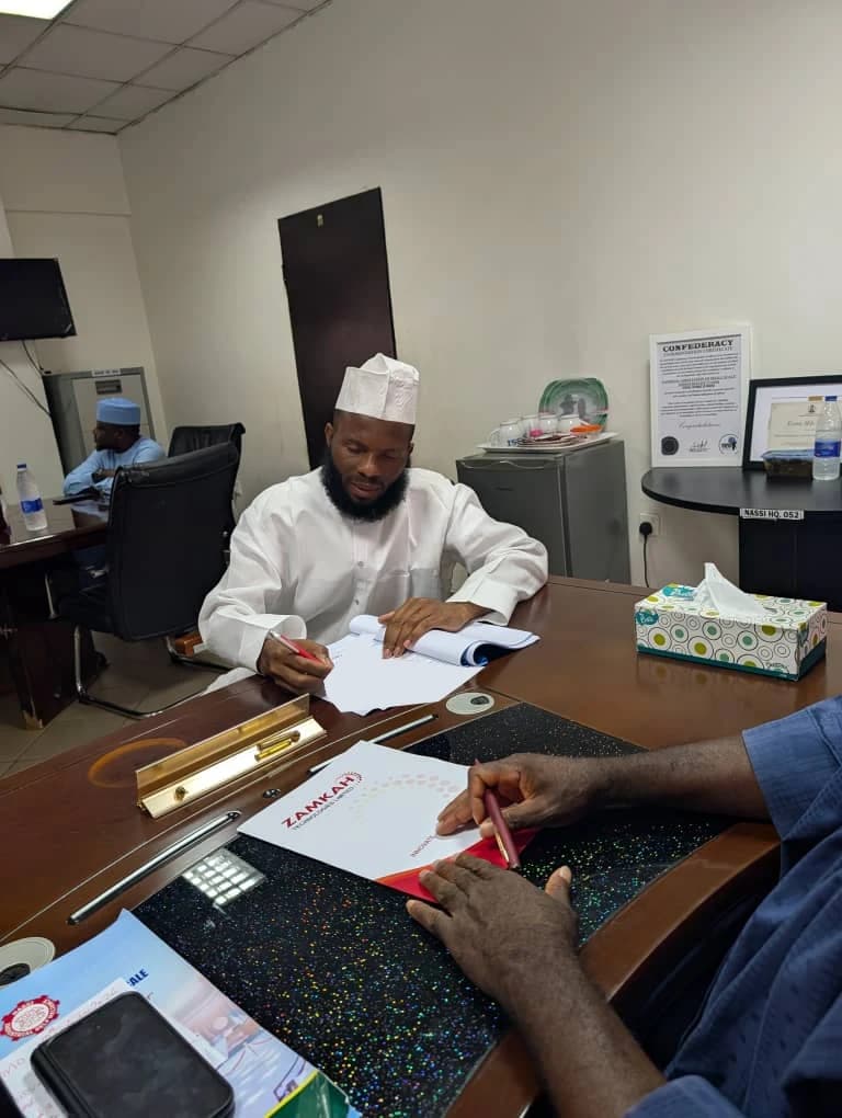 Signing ceremony for the NASSI and Zamkah consulting engagement, with private document details obscured.